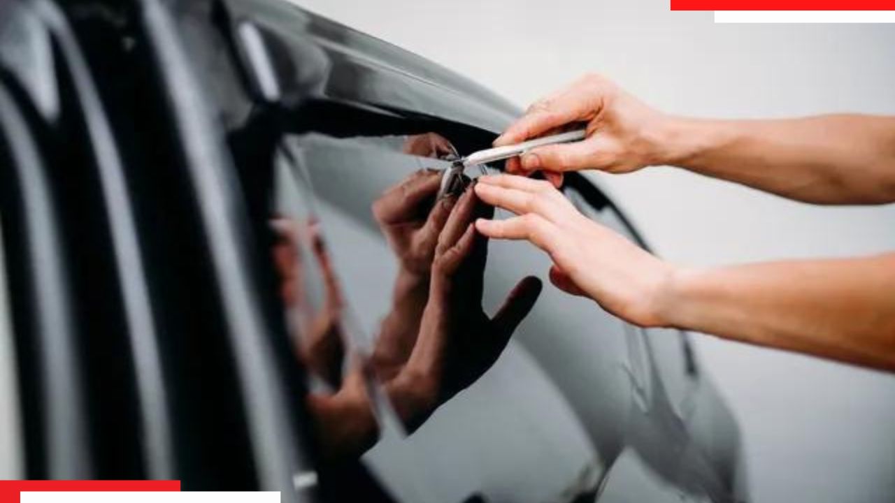 A person putting anti glare window film on a car